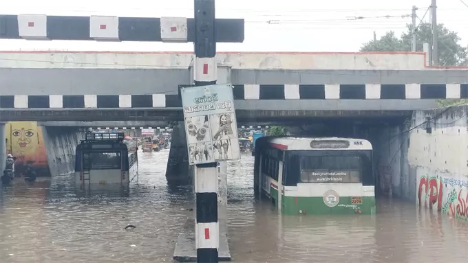 భారీ వర్షం.. వరదలో చిక్కుకున్న బస్సులు