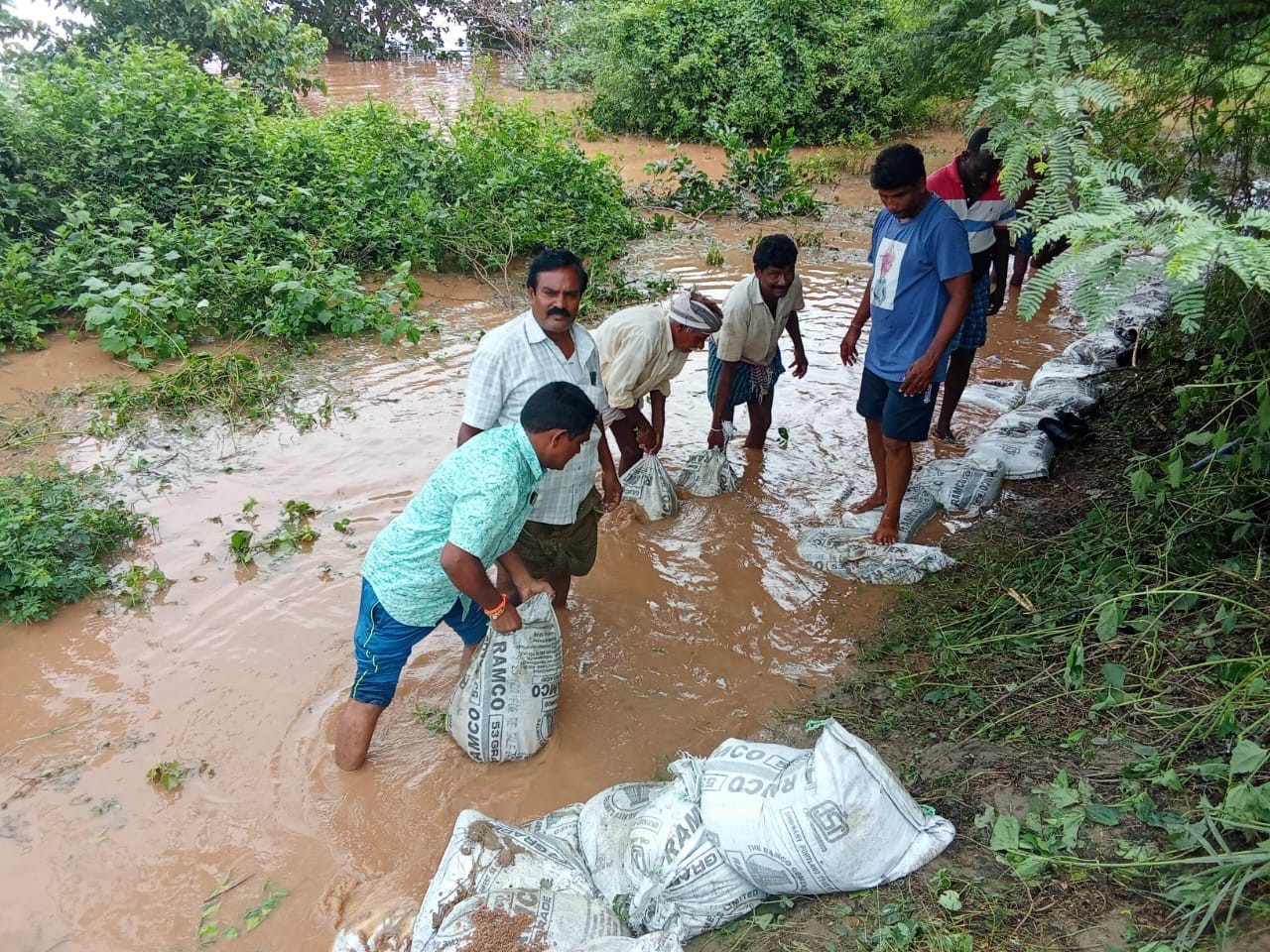 ఇసుక బస్తాలతో మార్గాన్ని ఏర్పాటు చేస్తున్న యువత