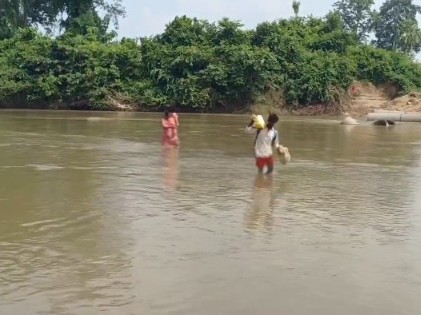 మోకాలి లోతు నీటిలో నడుస్తున్న ప్రజలు