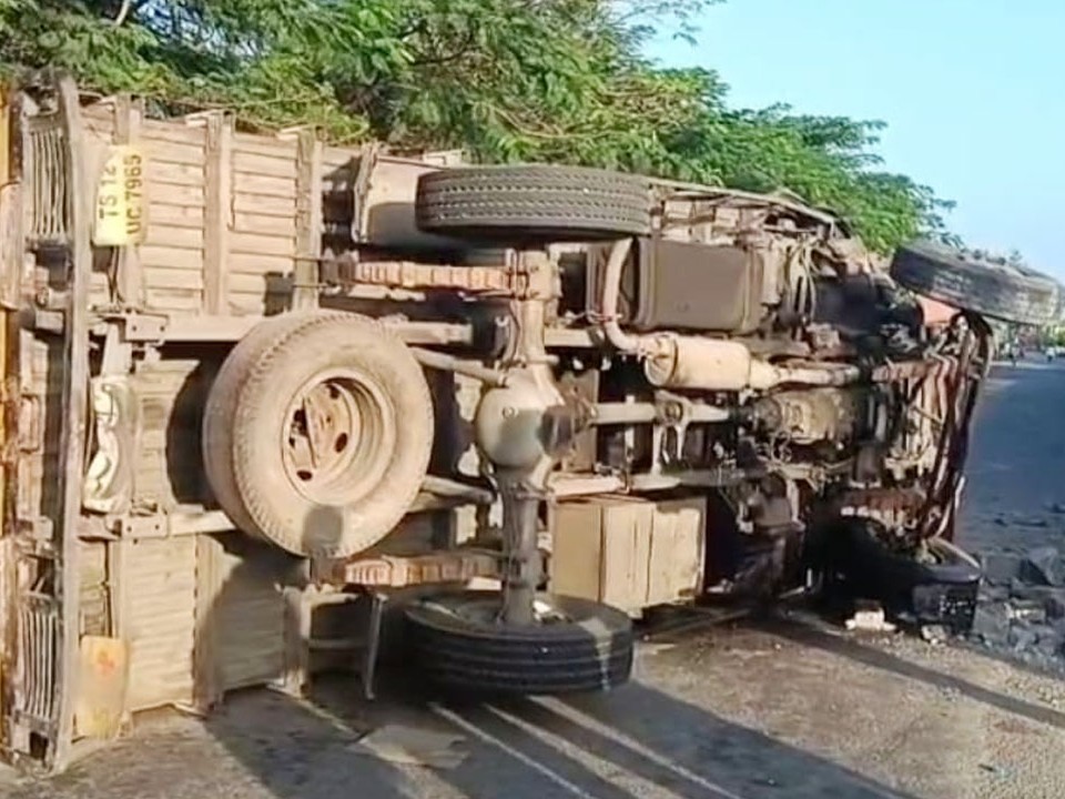 డివైడర్​ను ఢీకొని కంటైనర్​ బోల్తా