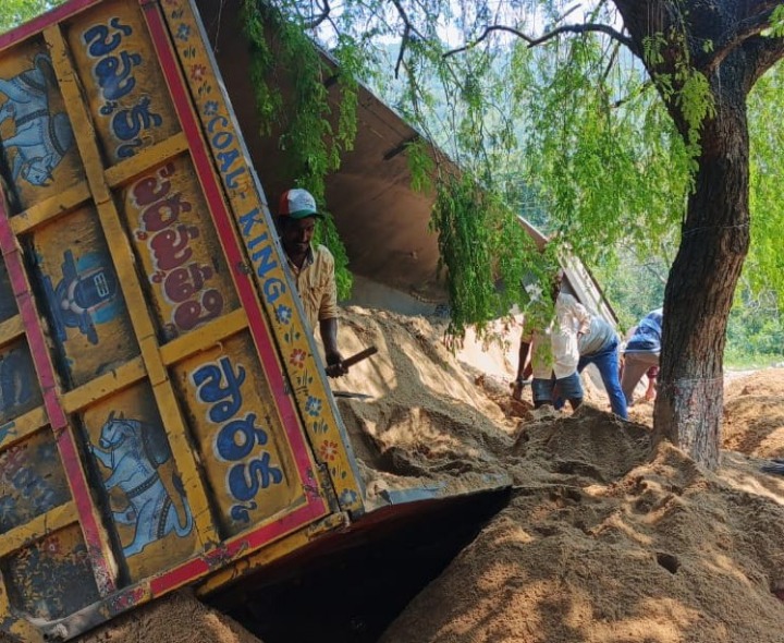 అన్‌లోడ్ చేస్తున్న ఇసుక లారీ బోల్తా