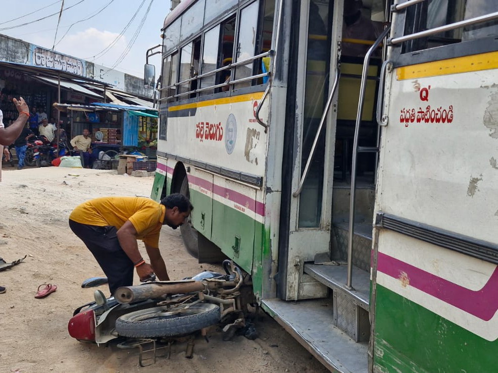 బస్సు కింద పడ్డ బైక్.. JUST MISS