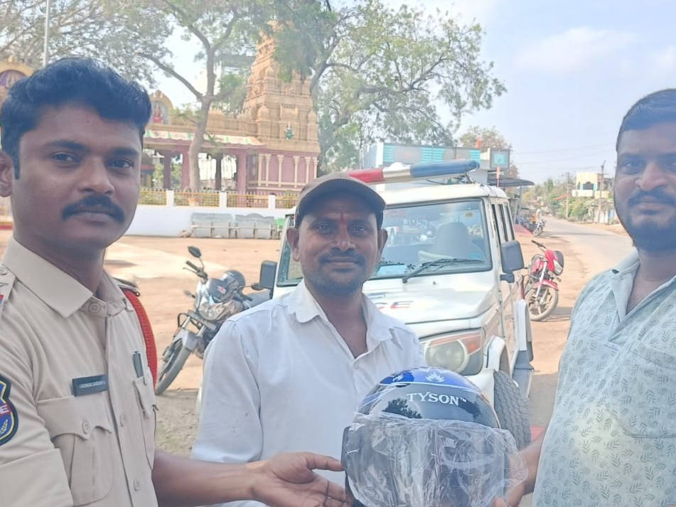 వాహనదారులకు హెల్మెట్లు పంపిణీ చేసిన ఎస్సై